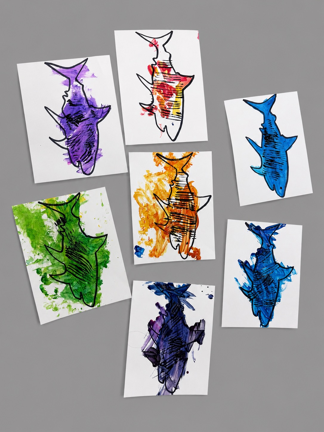 Colorful preschool shark paintings displayed on white paper